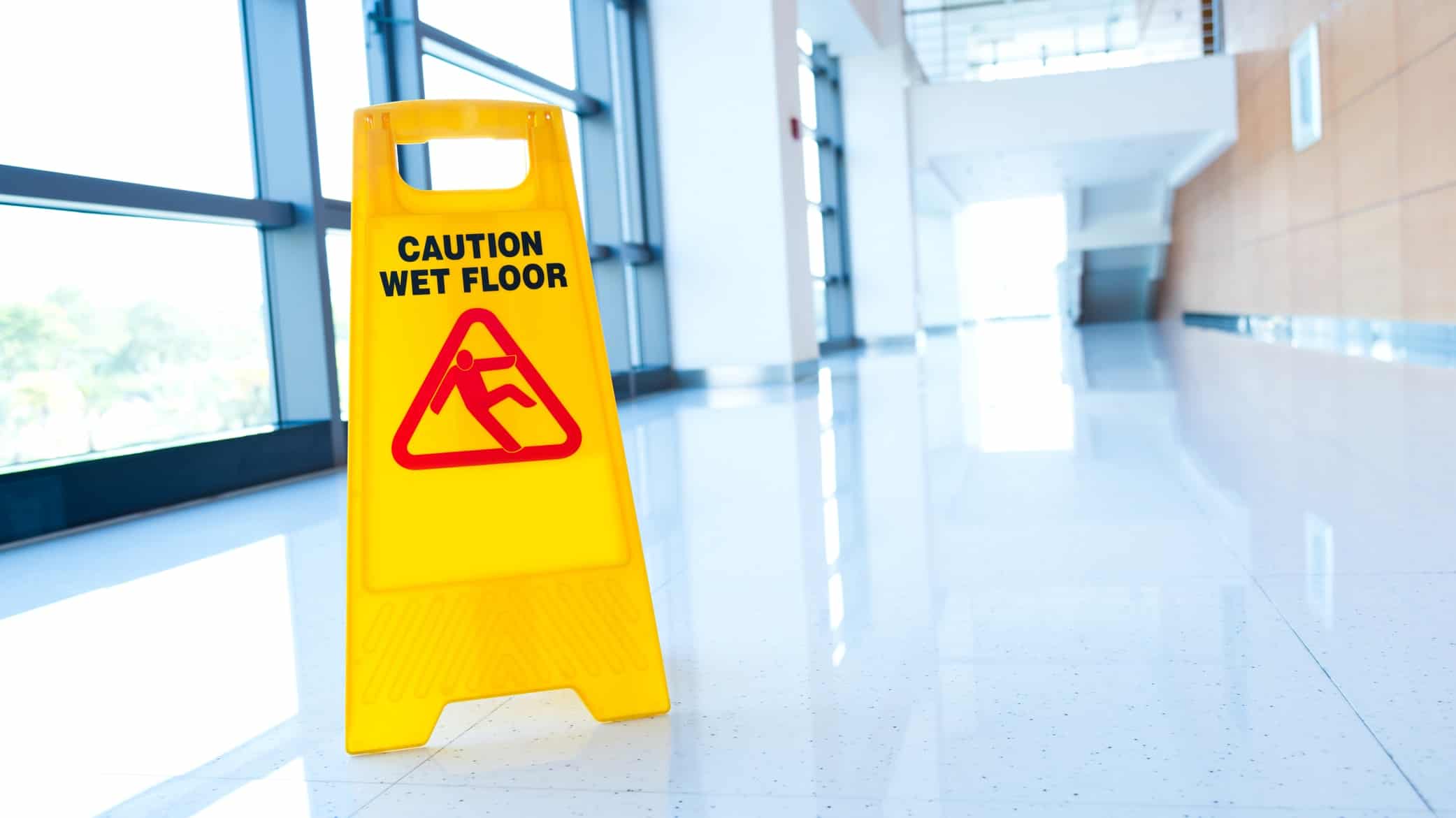 photo of wet floor sign to show boring office and why escape room teambuilding activities are so popular